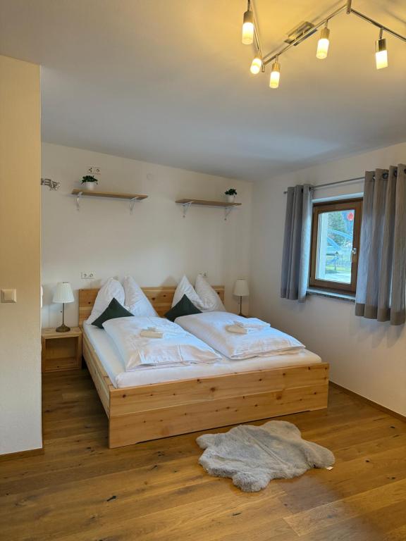 a bedroom with a wooden bed and a window at Zimmer Zur Säge in Kötschach