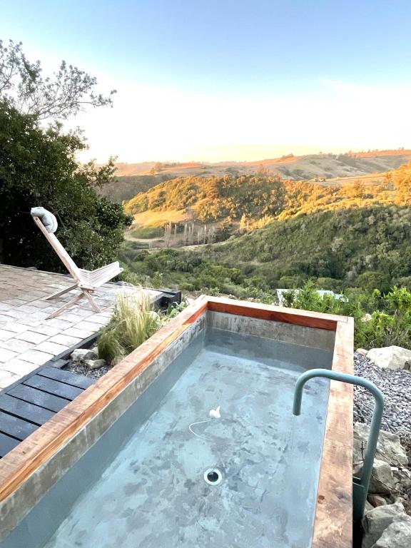 a hot tub with a view of a hill at Refugio costero Molle in Boca Pupuya