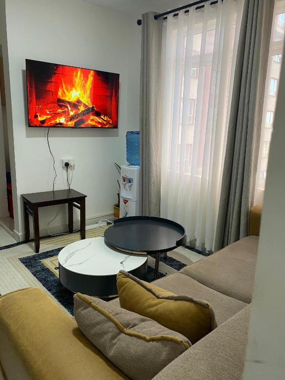 a living room with a couch and a fire on the wall at Residence Next Door Gz in Kiambu