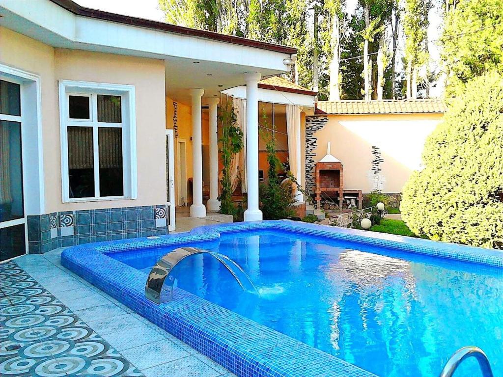 a swimming pool in front of a house at Hotel Home in Tashkent