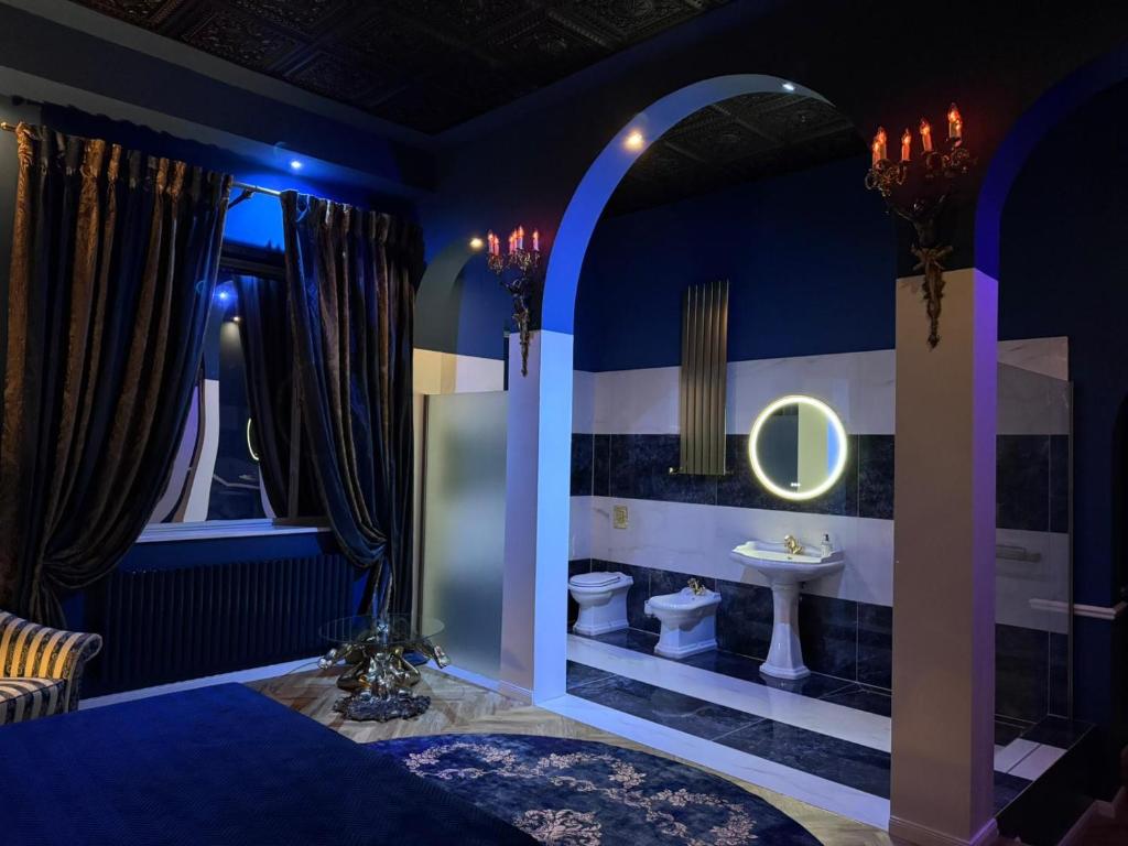 a blue bathroom with a toilet and a sink at Secret Labelle Époque Hideaway in Berlin