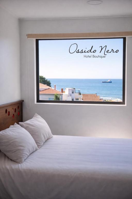 a bedroom with a bed with a view of the ocean at Hotel Boutique Ossido Nero in Viña del Mar