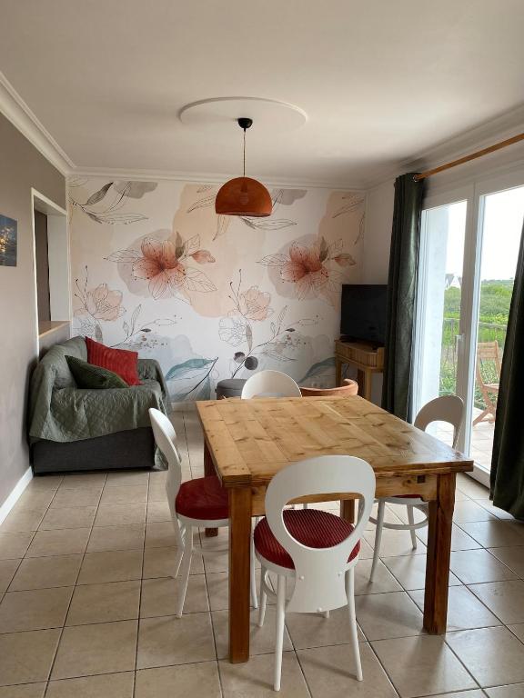 a dining room with a wooden table and chairs at Tall Ar Groas in Plogoff