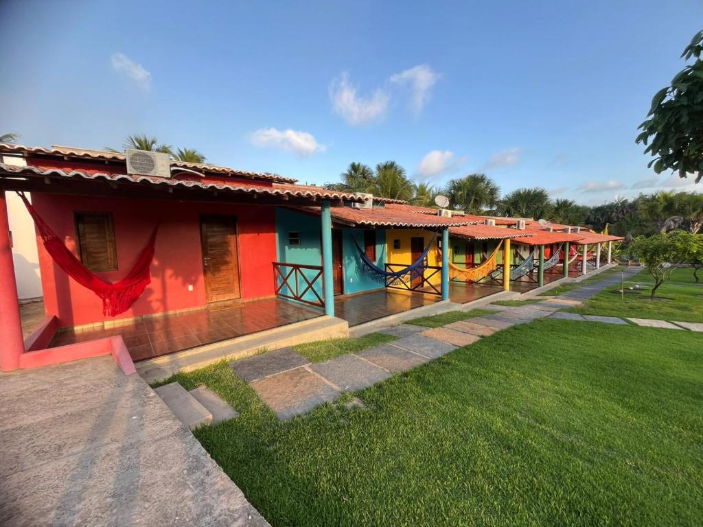a row of colorful houses in a yard at Chalé Rota Das Dunas in Barreirinhas