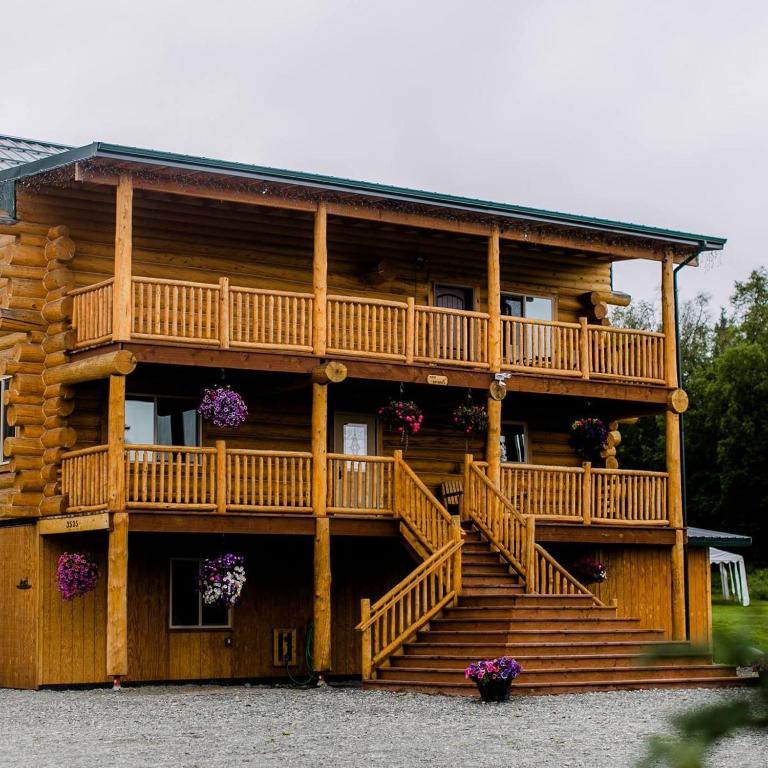 a log cabin with stairs and a balcony at Alaska Knotty Pine Whole Building in Palmer