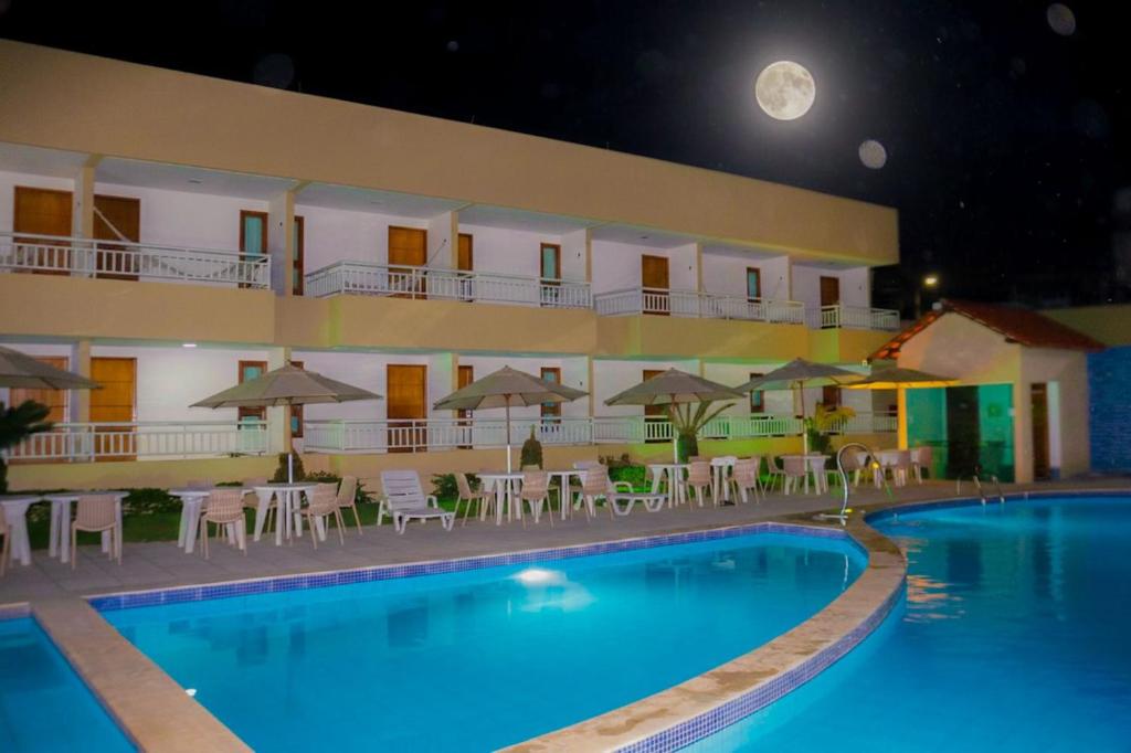 a hotel with a swimming pool at night at Porto da Serra Hotel in Gravatá