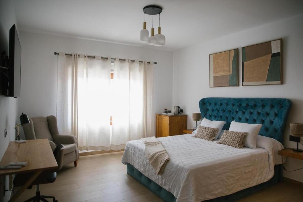 a bedroom with a bed and a chair and a window at Blue Petrol Room - Ocean Double Private Suite in Villa Barbuja in Tefía