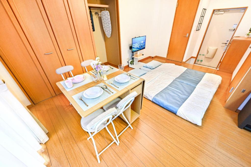 a bedroom with a bed and a table and chairs at 民泊 Ichinomiya K Room 1A in Ichinomiya