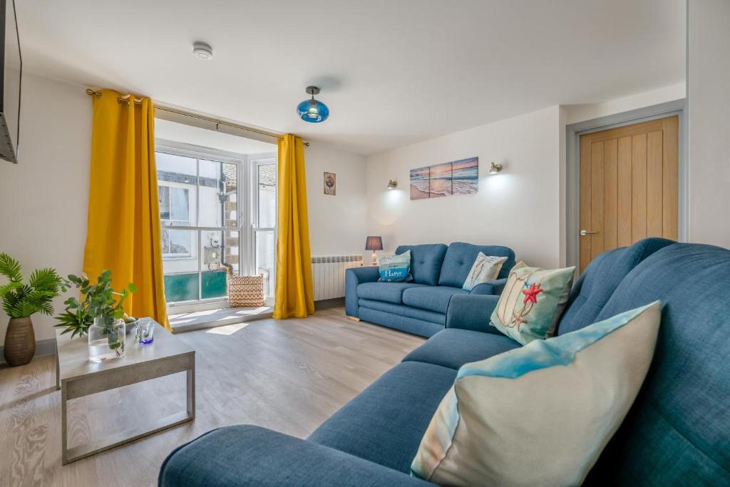 a living room with blue furniture and yellow curtains at 2 Bed in St. Ives oc-e28156 in St Ives