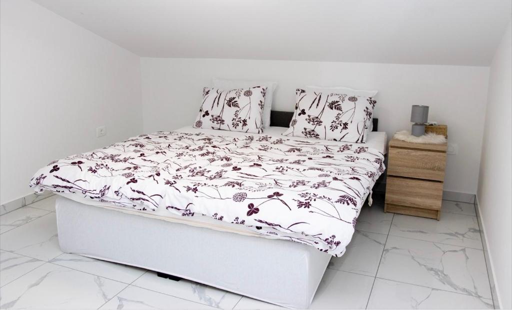a bedroom with a bed with a floral bedspread at Gostišče cimi in Kozina