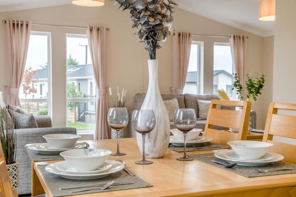 a dining room table with wine glasses and a vase at 2 Bed in Evesham oc-f33689 in Admington