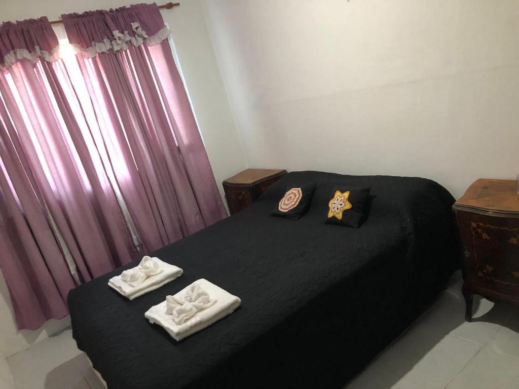 a bedroom with a black bed with towels on it at Espacio Marea in Puerto Madryn
