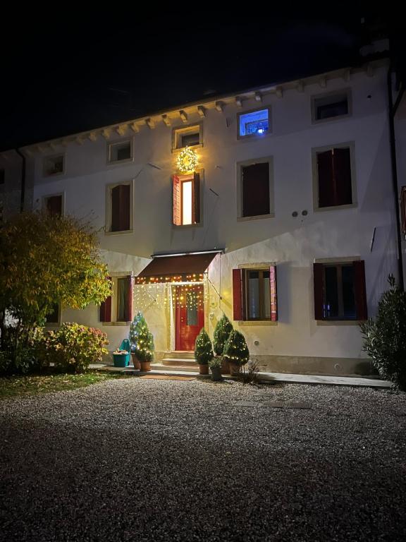 a white building with christmas lights in front of it at Casa Agostini Bed and Breakfast in Farra di Soligo