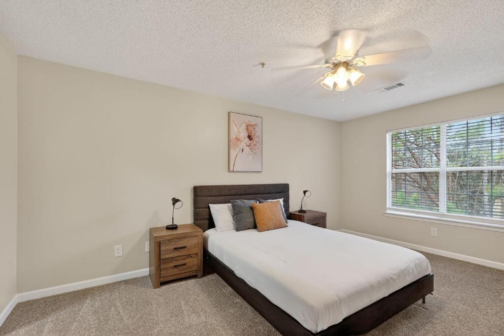 a bedroom with a bed and a ceiling fan at Bright Stockbridge condo with full kitchen in Stockbridge