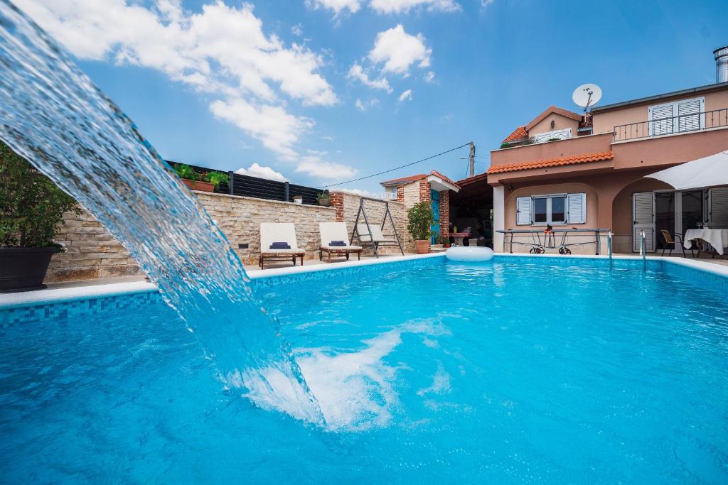 a pool with a water fountain in a yard at Villa Peaceful Valley in Šestanovac
