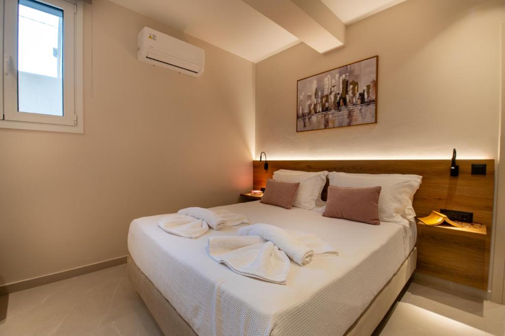 a bedroom with a bed with towels on it at Mystrali 1BD Modern Apt with Private Garden in Galatás