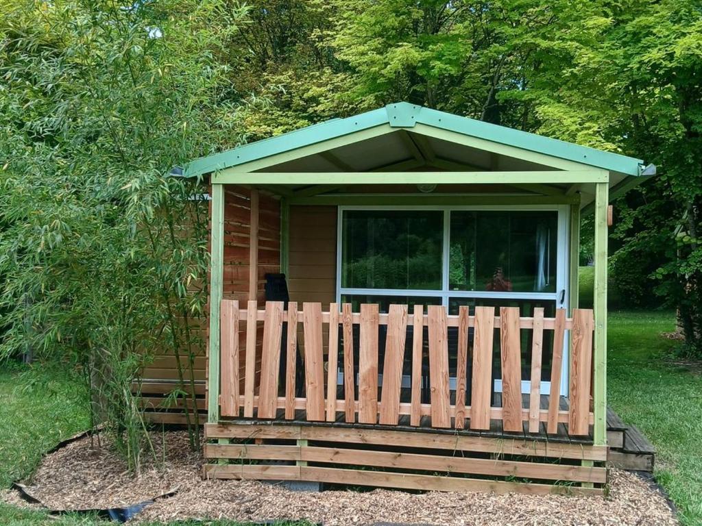 a small house with a wooden fence in the yard at Chalet 5 Pers avec Terrasse - API-1-52-1125 in Vendoire