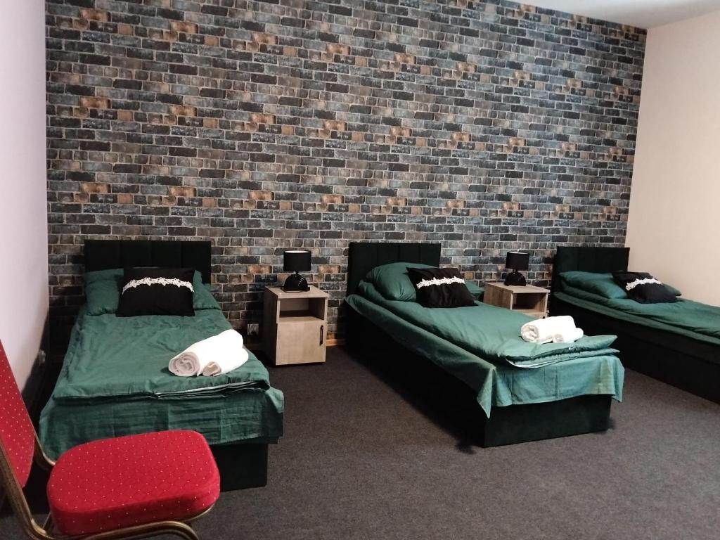 a room with two beds and a brick wall at Villa Varzob lll in Warsaw