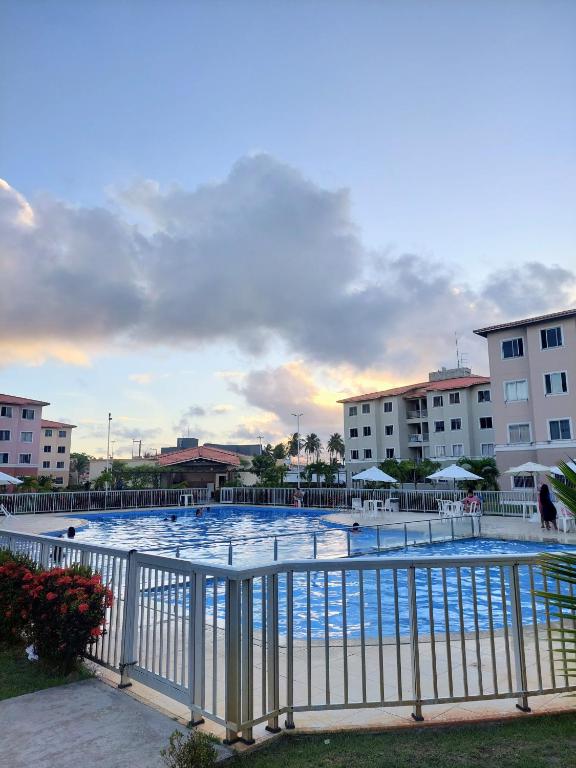 a large swimming pool next to some buildings at Residencial Clube Recanto dos Coqueiros in Aracaju