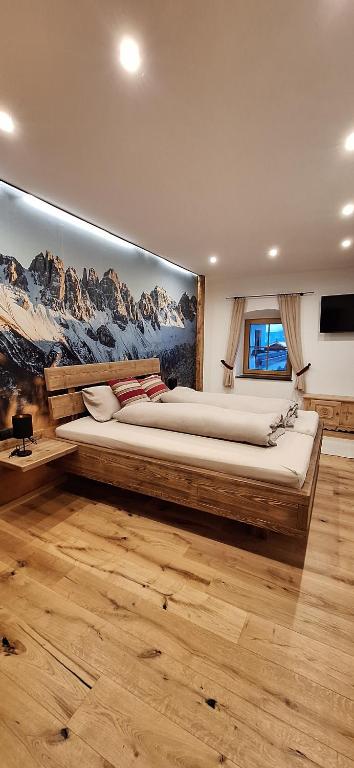 a bedroom with a large bed with a painting on the wall at alter Hannelerhof in Mutters