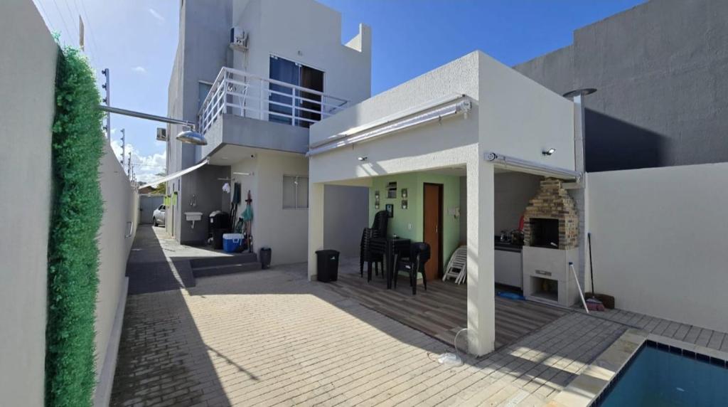 a house with a patio and a swimming pool at Jacumã Gold in Conde