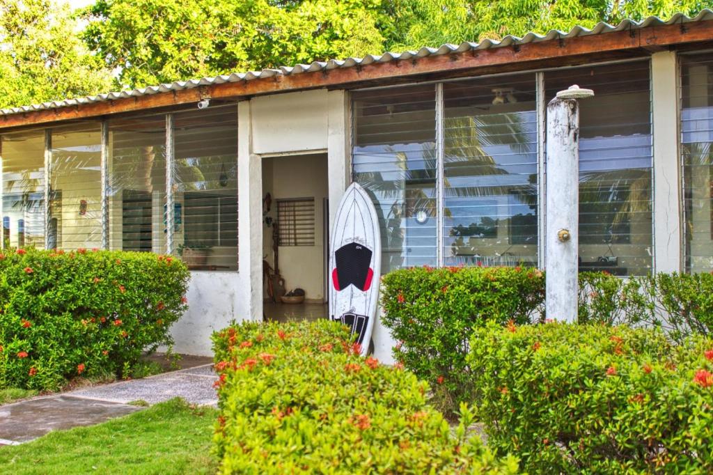 a white house with a chair in front of it at Casa Libre Guest House in Conchagua