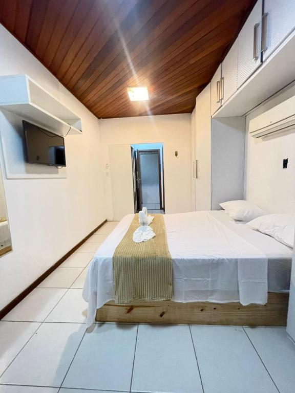 a bedroom with a large bed and a tv at Apartamento Rangel in Cairu