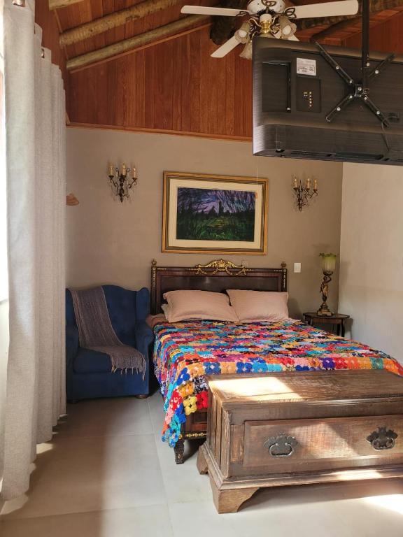 a bedroom with a bed and a blue couch at Na Trilha da Ostra 2 - Brechó e Antiquário in Brumadinho