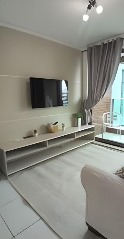 a living room with a tv on the wall at Apartamento Completo 608 Monte Fuji, Praia de Cabo Branco in João Pessoa