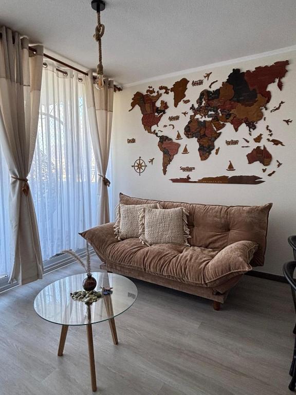 a living room with a couch and a world map on the wall at Apartment steps away from the beach in La Serena