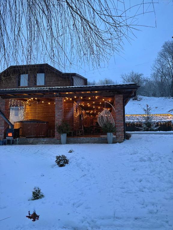 a house with lights on it in the snow at Будинок з лазнею in Mizhhirya