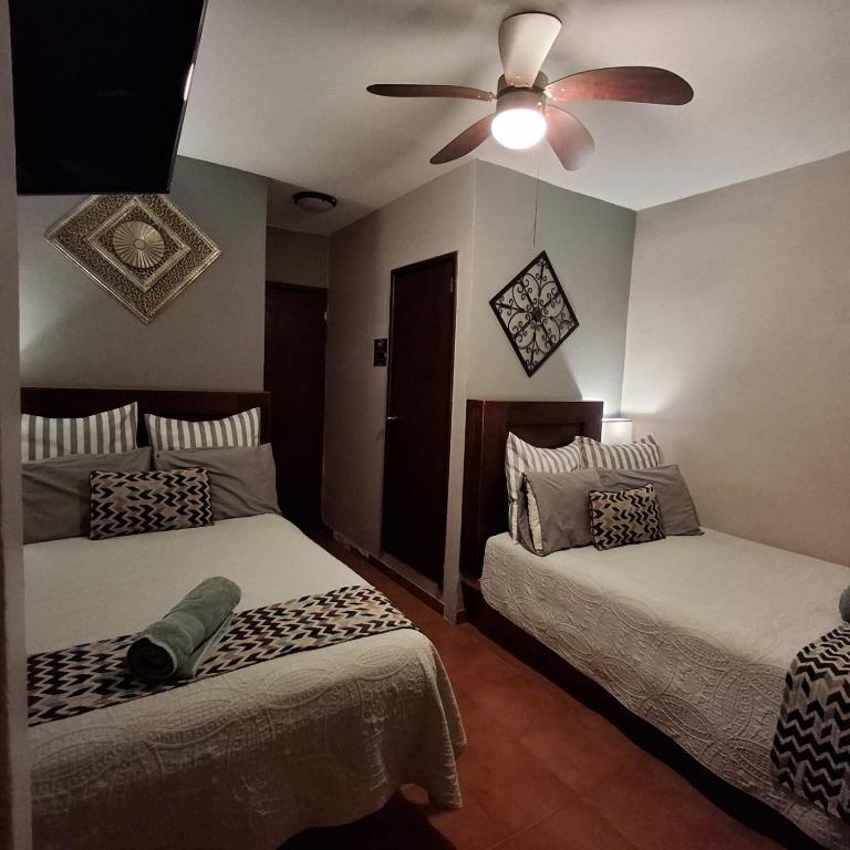 a bedroom with two beds and a ceiling fan at Hotel Hacienda Entabladero in Entabladero