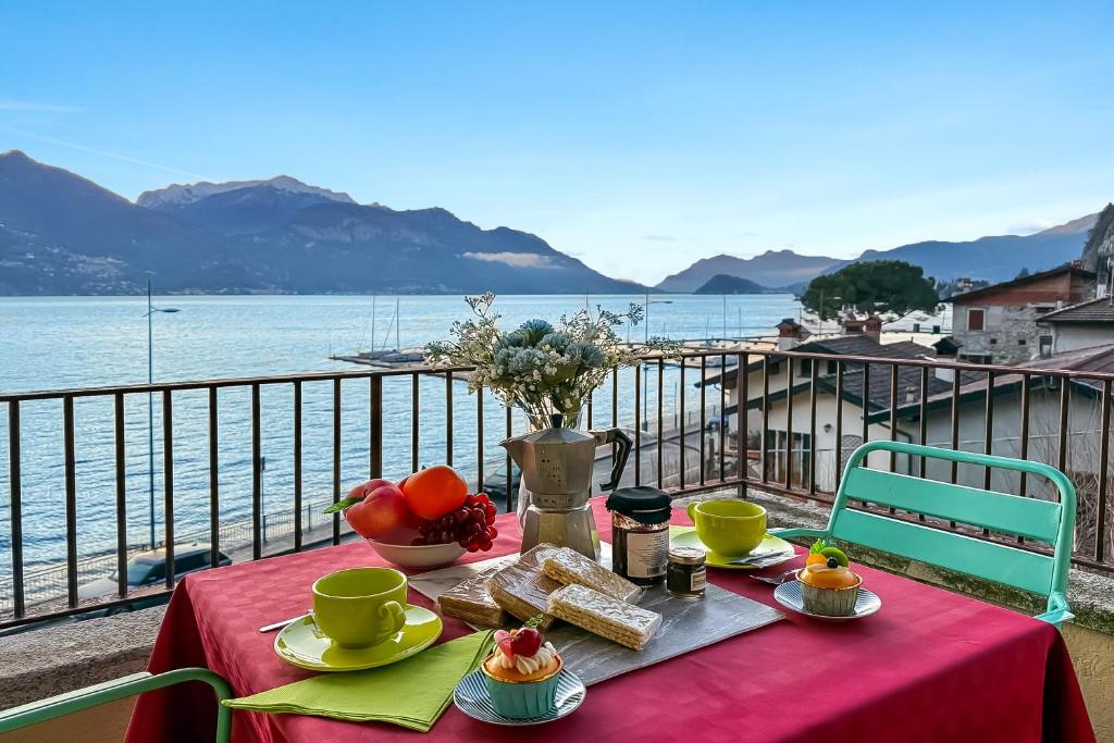 a table with food and a vase of flowers on a balcony at Residenza Menaggio - Mimosa in Menaggio