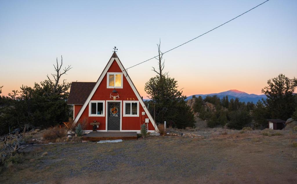 a small red house in the middle of a field at The Cozy Owl A-Frame in Jefferson