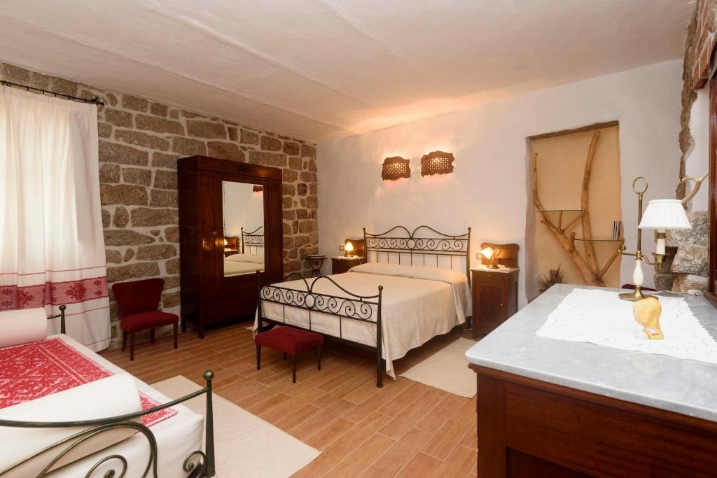 a bedroom with a bed and a stone wall at Al Vecchio Corso B&B in Tempio Pausania