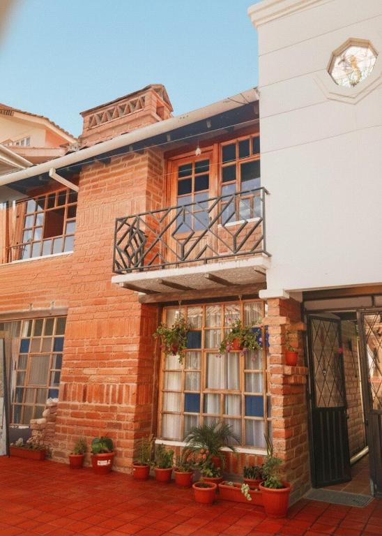 a brick building with a balcony and plants at Casa acogedora y espaciosa in Huamboya