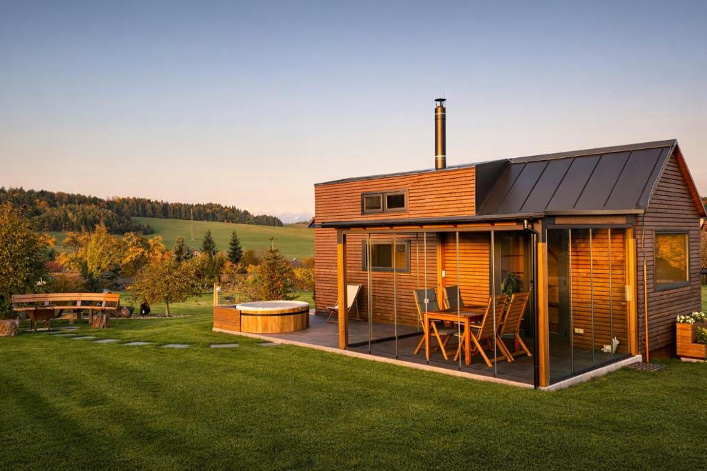 a house with a deck and a table in a field at Domek pod Zvičinou in Dvůr Králové nad Labem