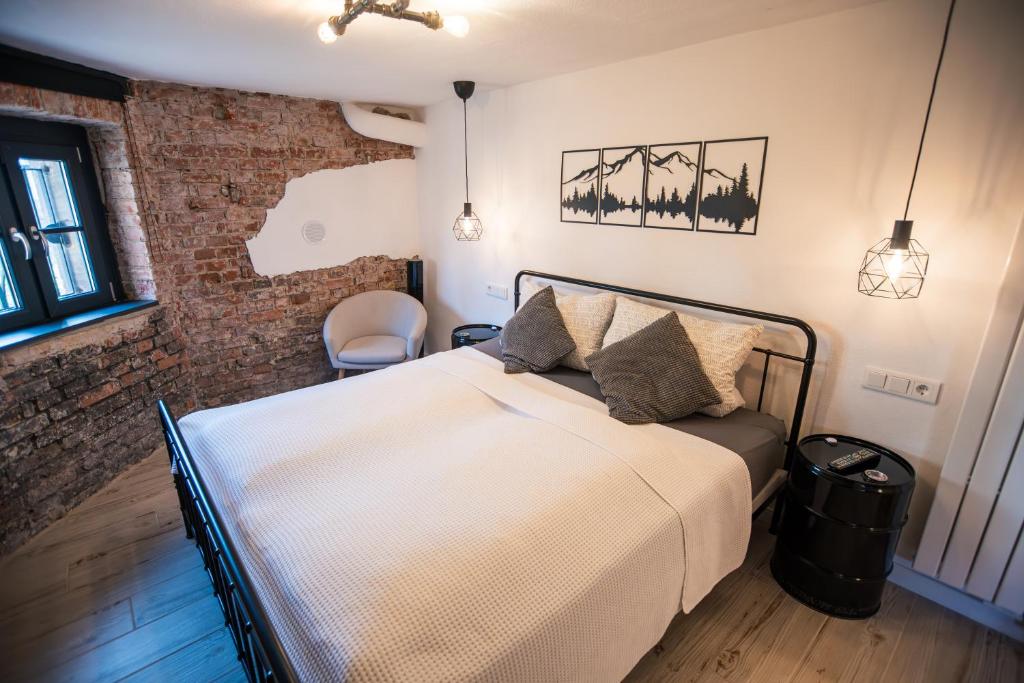 a bedroom with a bed and a brick wall at Apartment 22 - zentrumsnah - Parkplatz in Coburg