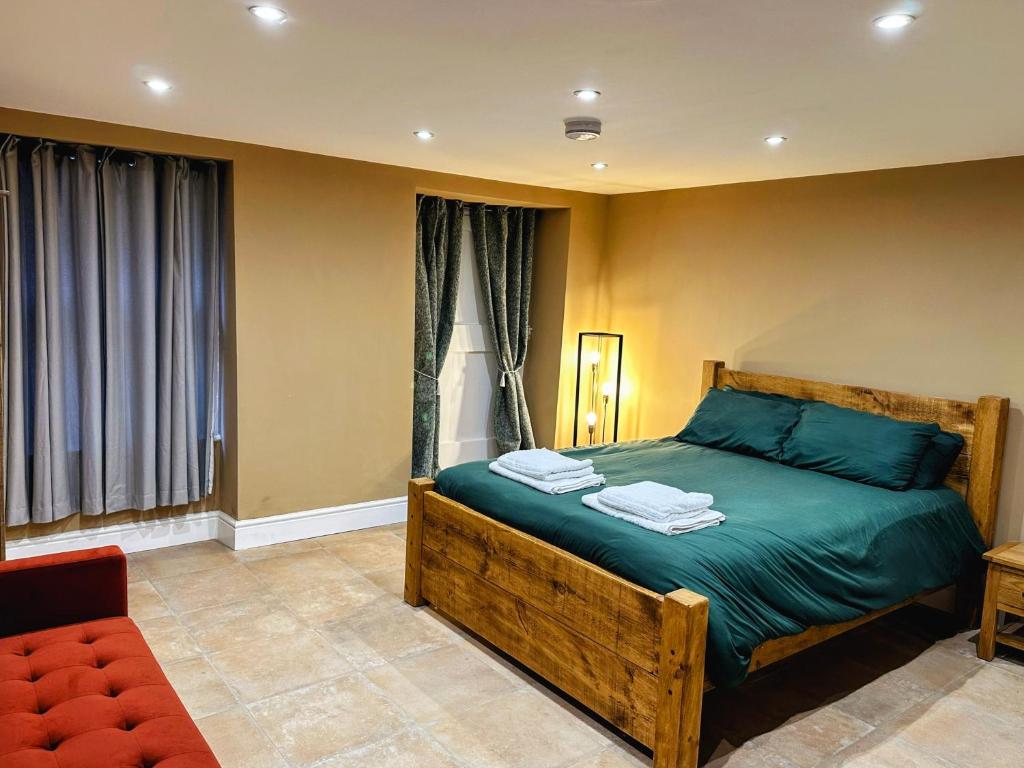 a bedroom with a bed with green sheets and a chair at Ground floor, Very central, 2 Bed - Cobbles Apartment in Buxton