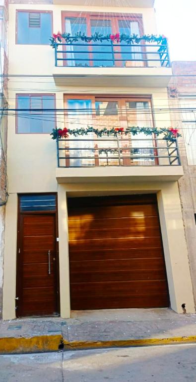 two garage doors in front of a building with a balcony at Residencial SKD in Puno
