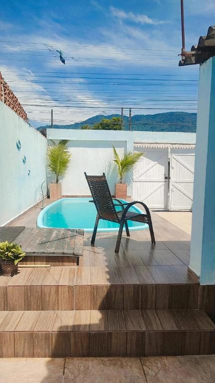 a bench sitting on a deck next to a pool at Recanto do mar in Caraguatatuba
