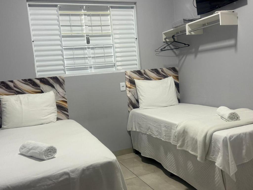two twin beds in a room with a window at Amazon LOFT 08 in Sorriso