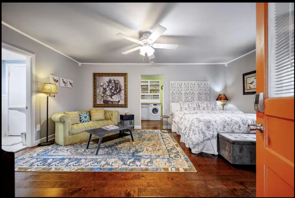 a bedroom with a bed and a couch and a ceiling fan at Peaceful Private Cottage, Walk to Park & 5 Mins to Downtown in Nashville