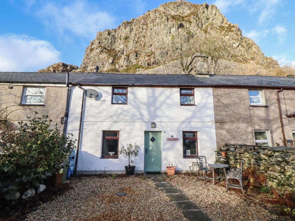 a house with a mountain in the background at Old Station Cottage in Blaenau-Ffestiniog