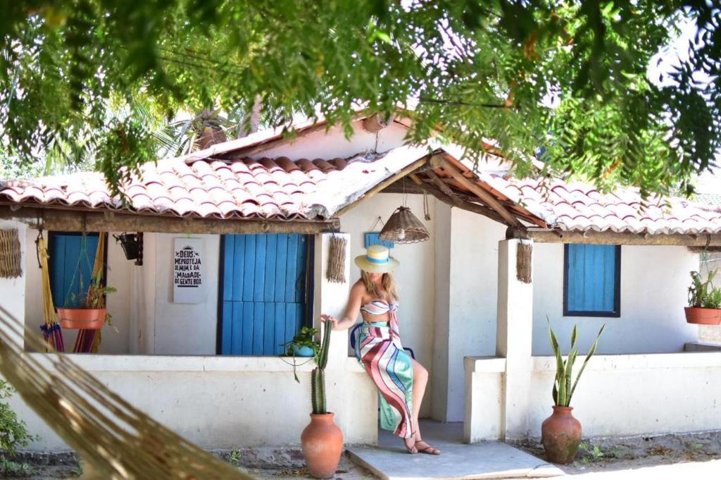 a woman standing in front of a house at Vila Borogodó- Casa in Barra Grande