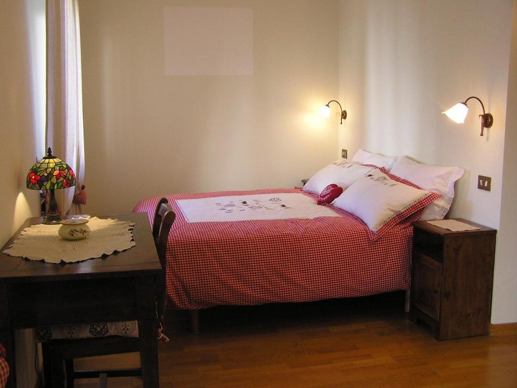 una piccola camera con letto e tavolo di B&B Au Petit Bonheur a Saint Vincent