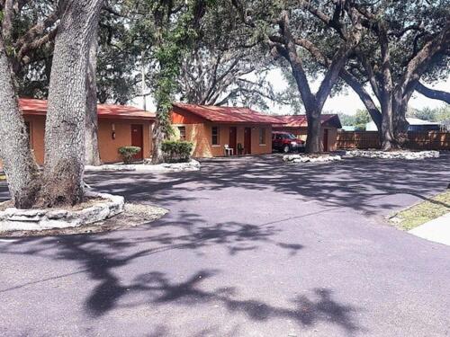 a house with trees in front of a driveway at Star Motel in Tampa