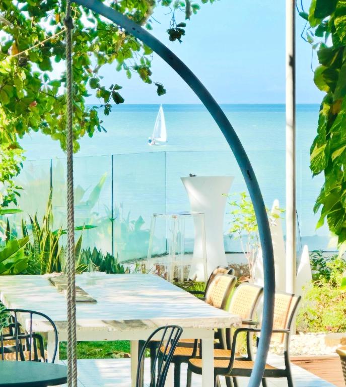a table and chairs with a view of the ocean at Smell rose beach garden in Batu Ferringhi
