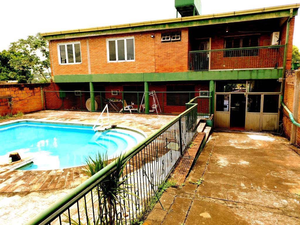 a house with a swimming pool in front of a building at Posada Familiar ELDORADO in Eldorado