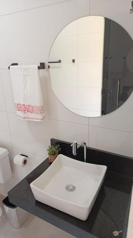 a bathroom with a white sink and a mirror at Espaço Real in Manhã